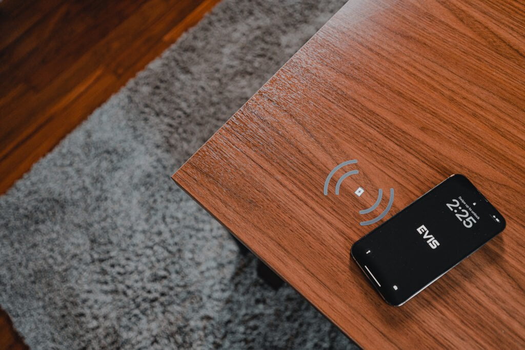 Smart CEO desk with integrated wireless charging feature, displayed with a smartphone placed on the charging pad.